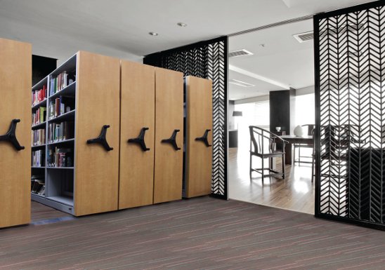 Corporate / legal high-density mobile shelving with wood-clad end panels in a professional office environment